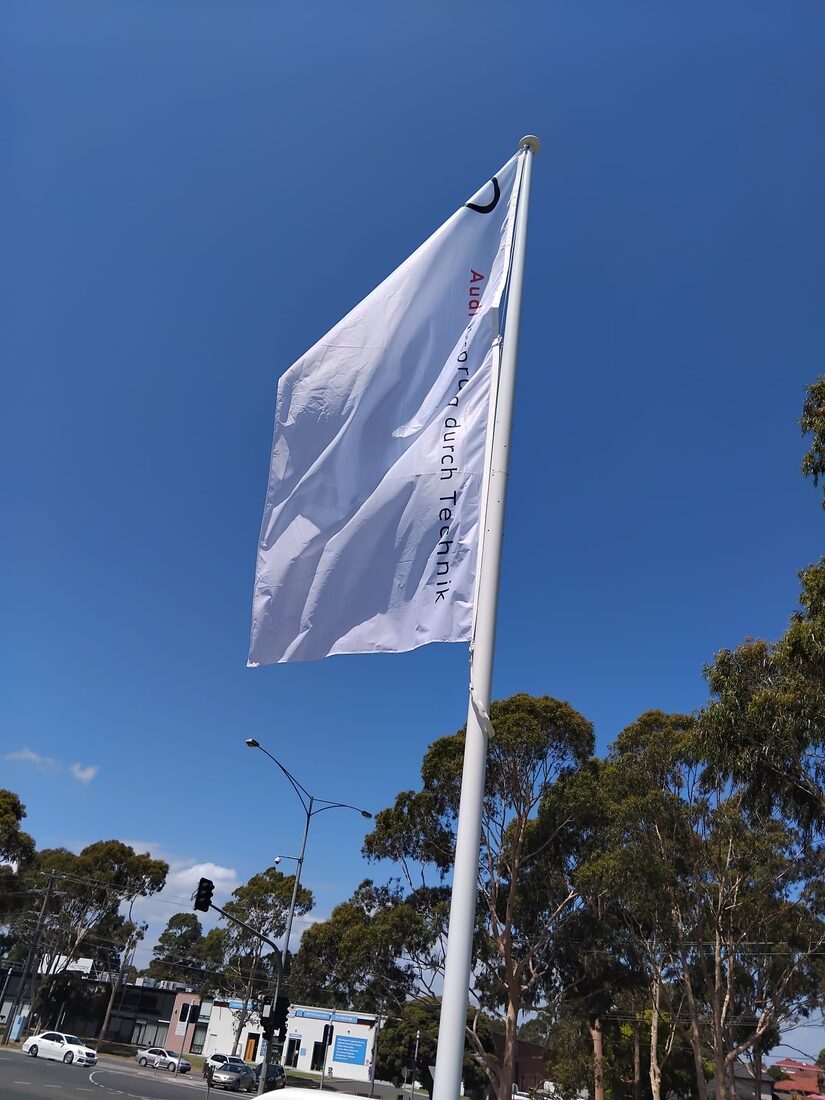 A custom printed business flag flying outdoors