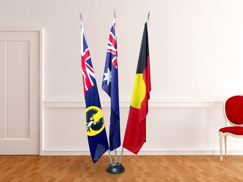 An indoor flagpole set with three flags