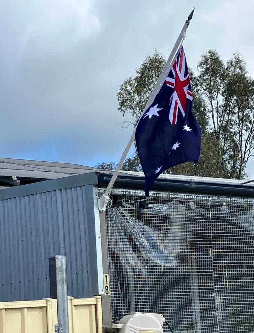 An Australian flag on a wall mounted bracket flagpole